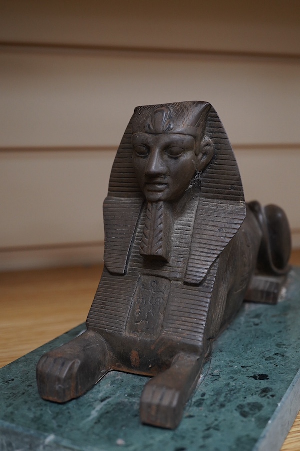 A pair of cast iron models of Sphinxes, raised on green serpentine marble bases, 32cm long. Condition - fair, both detached from bases